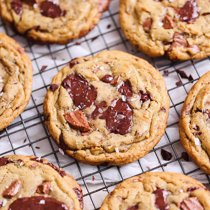 a batch of chocolate chip cookies on a drying rack