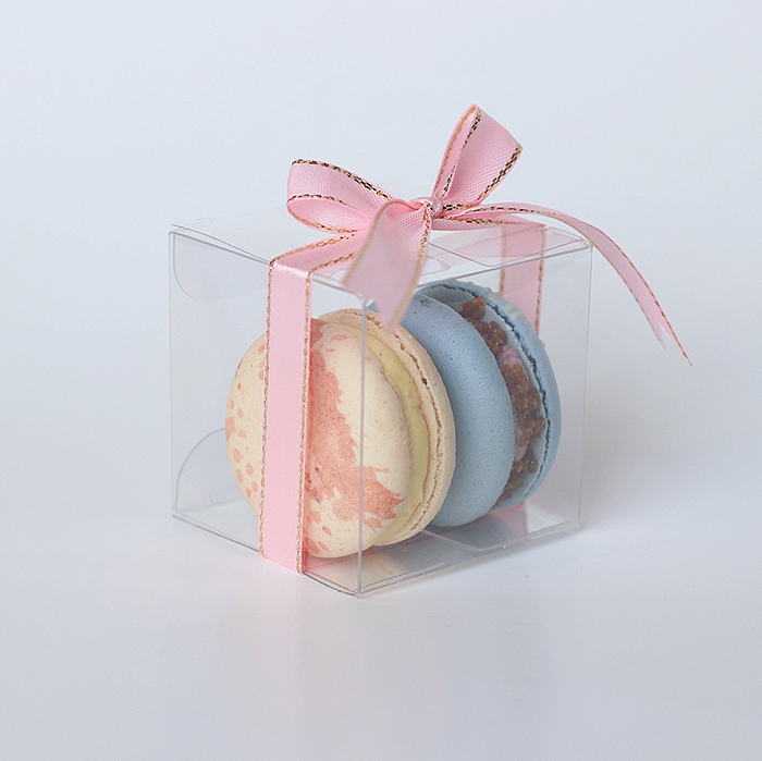 2 macarons stacked inside a clear cube shaped box